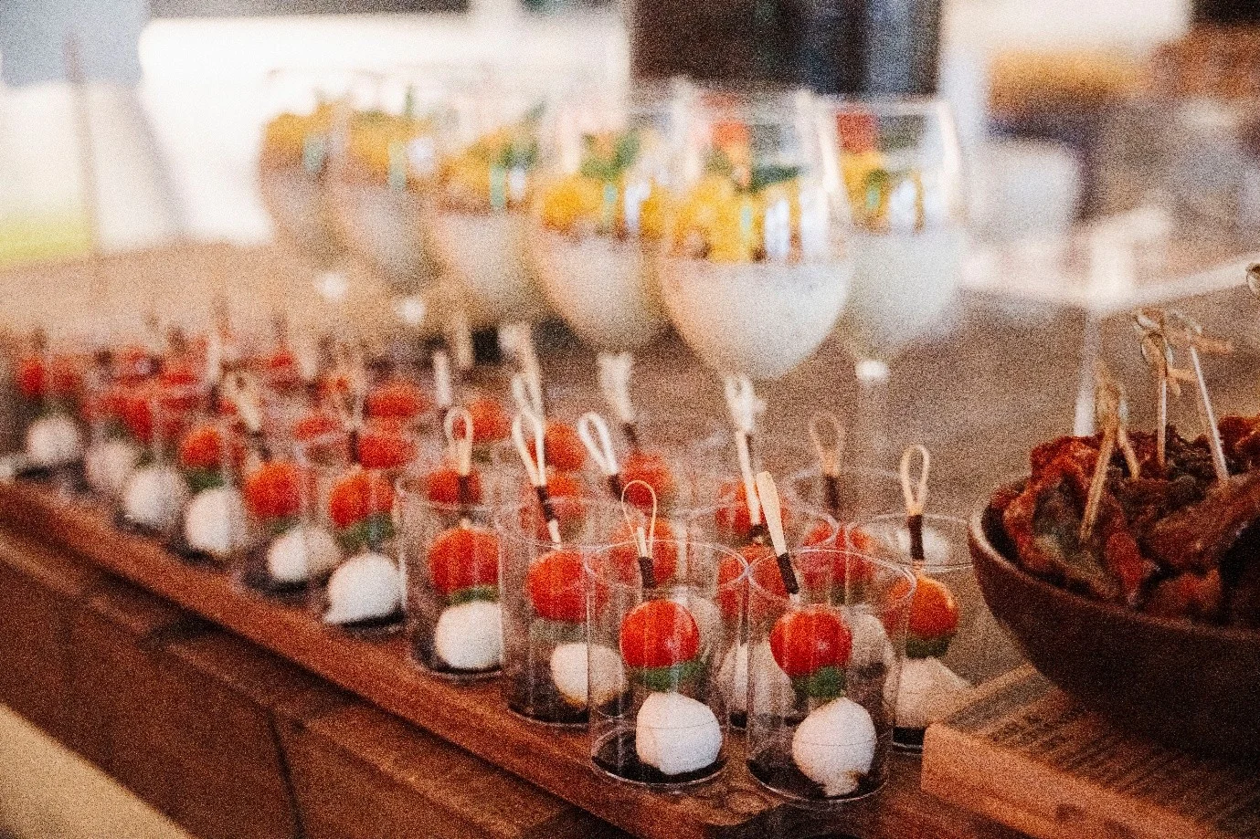 Tomato and mozzarella bites in small glasses on a wooden board at a private event in Neuss