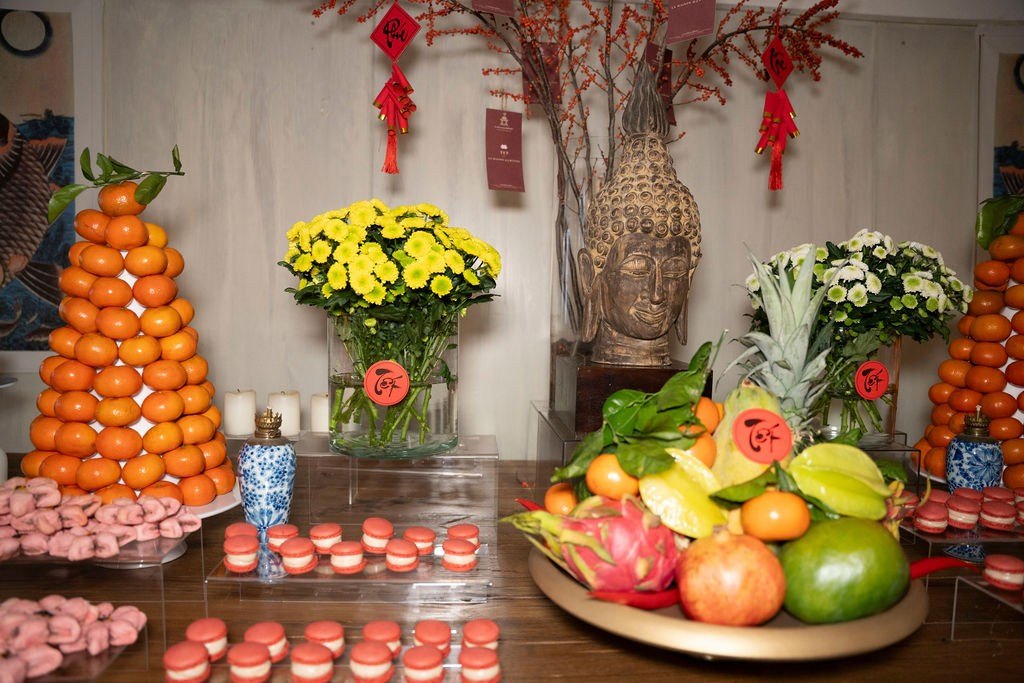 Tết table with mandarins, chrysanthemums and a Buddha head