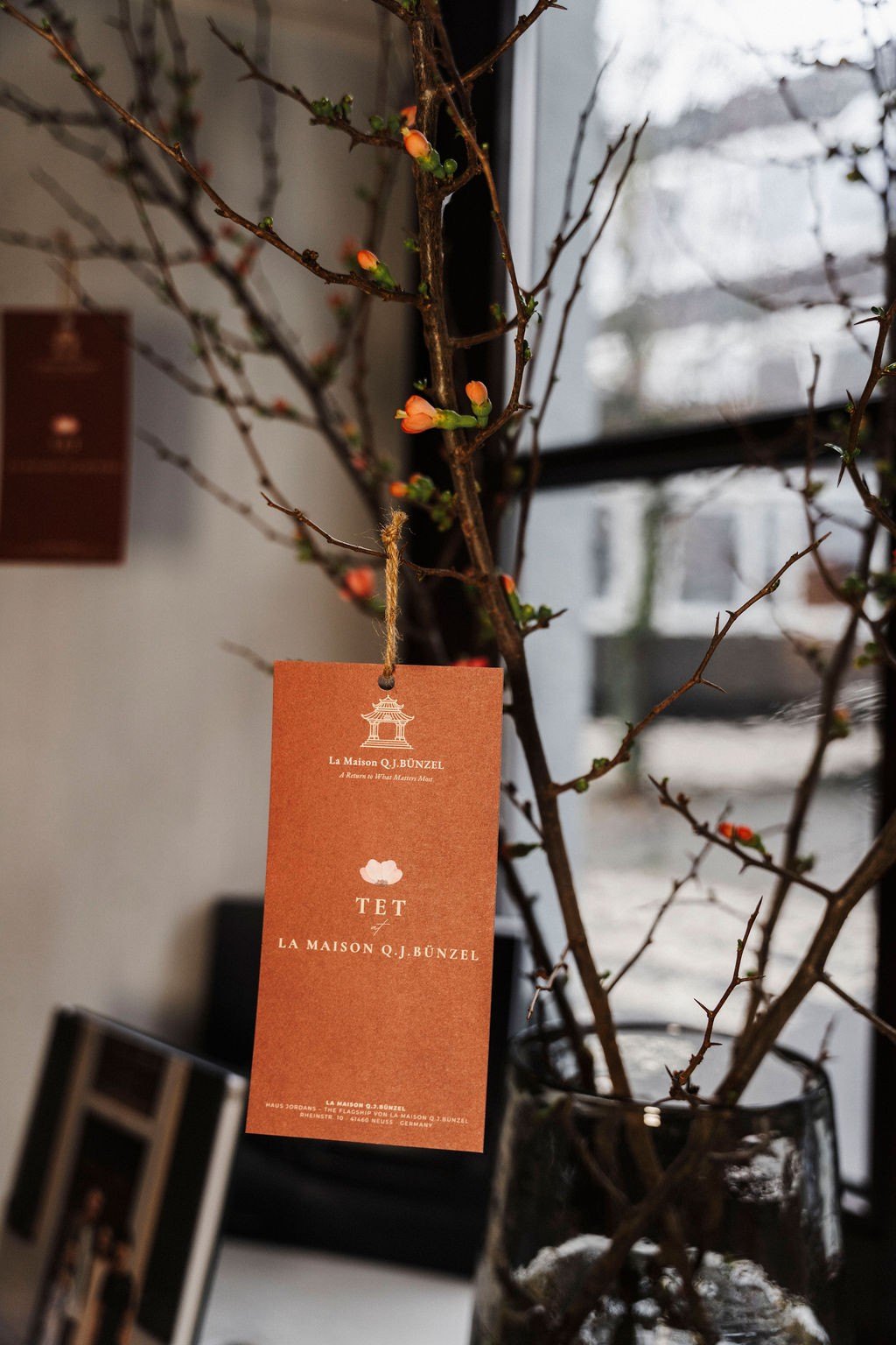 Tết tag of La Maison on a blossom branch